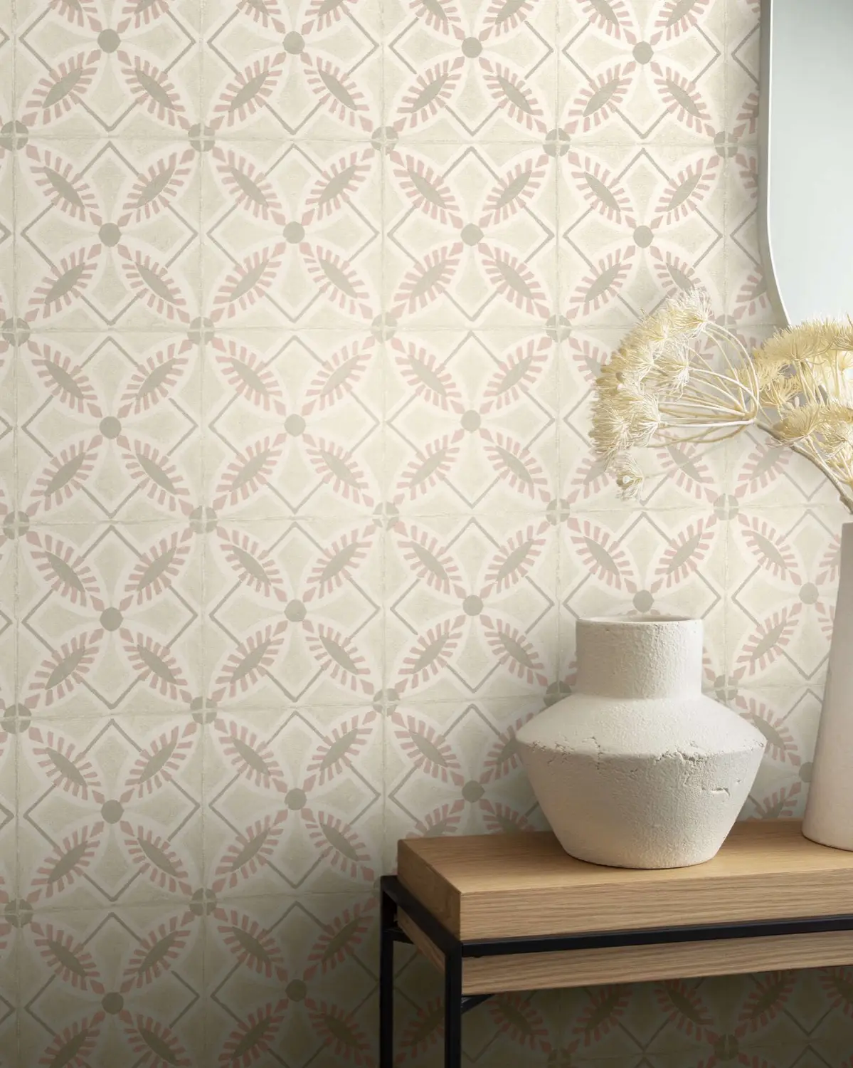 Papier peint à motif géométrique beige, console en bois et vases blancs