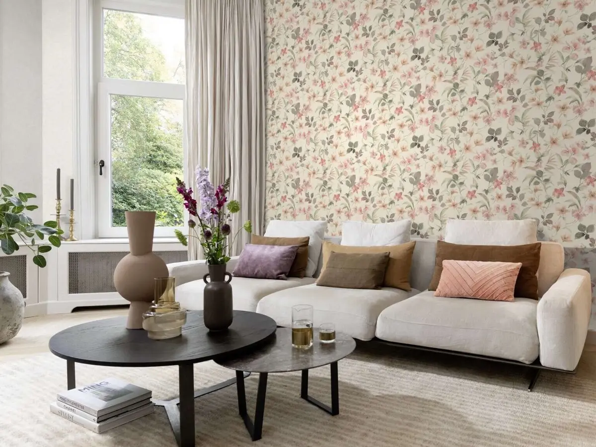 Salon lumineux, tapis clair sous les tables basses, papier peint fleuri au mur
